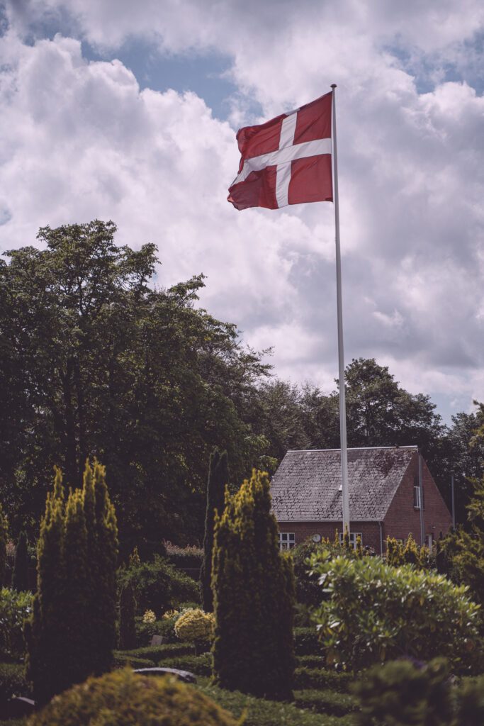 Foto einer dänischen Flagge auf dem Platz vor einer Kirche in der Nähe von Kolding, Dänemark